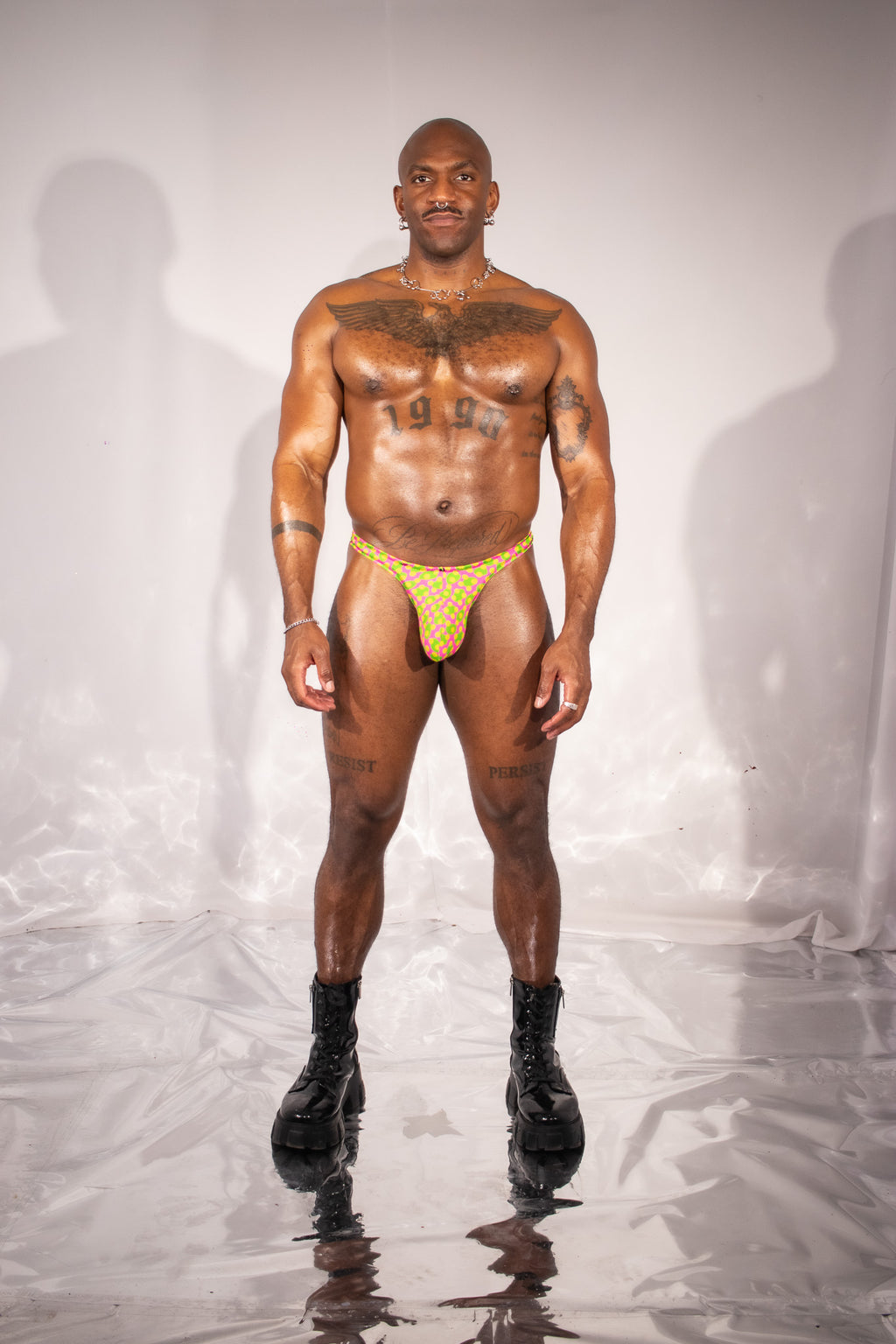 Man wearing a yellow thong against a plain background