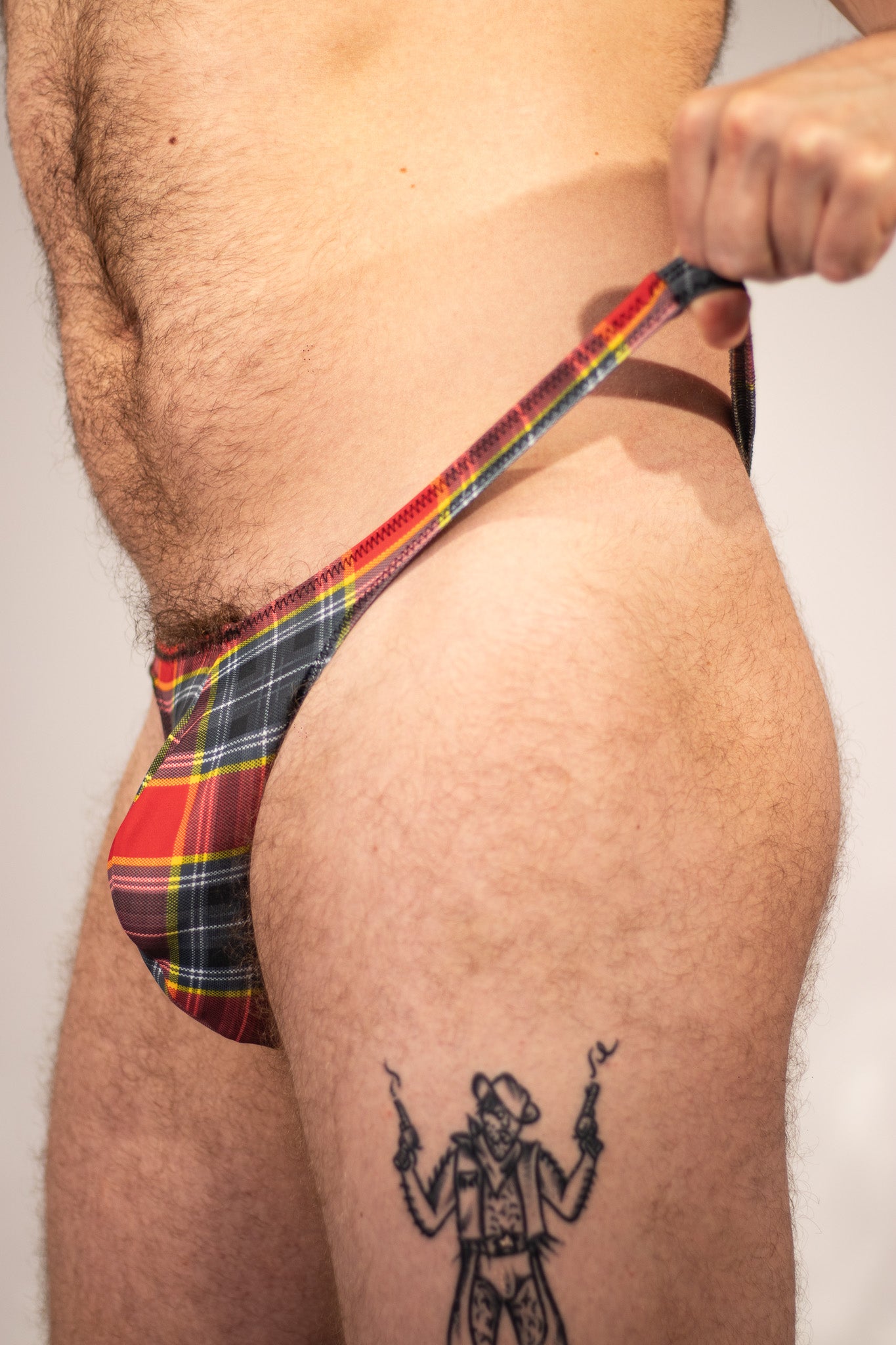 Person wearing a plaid thong with a plain background