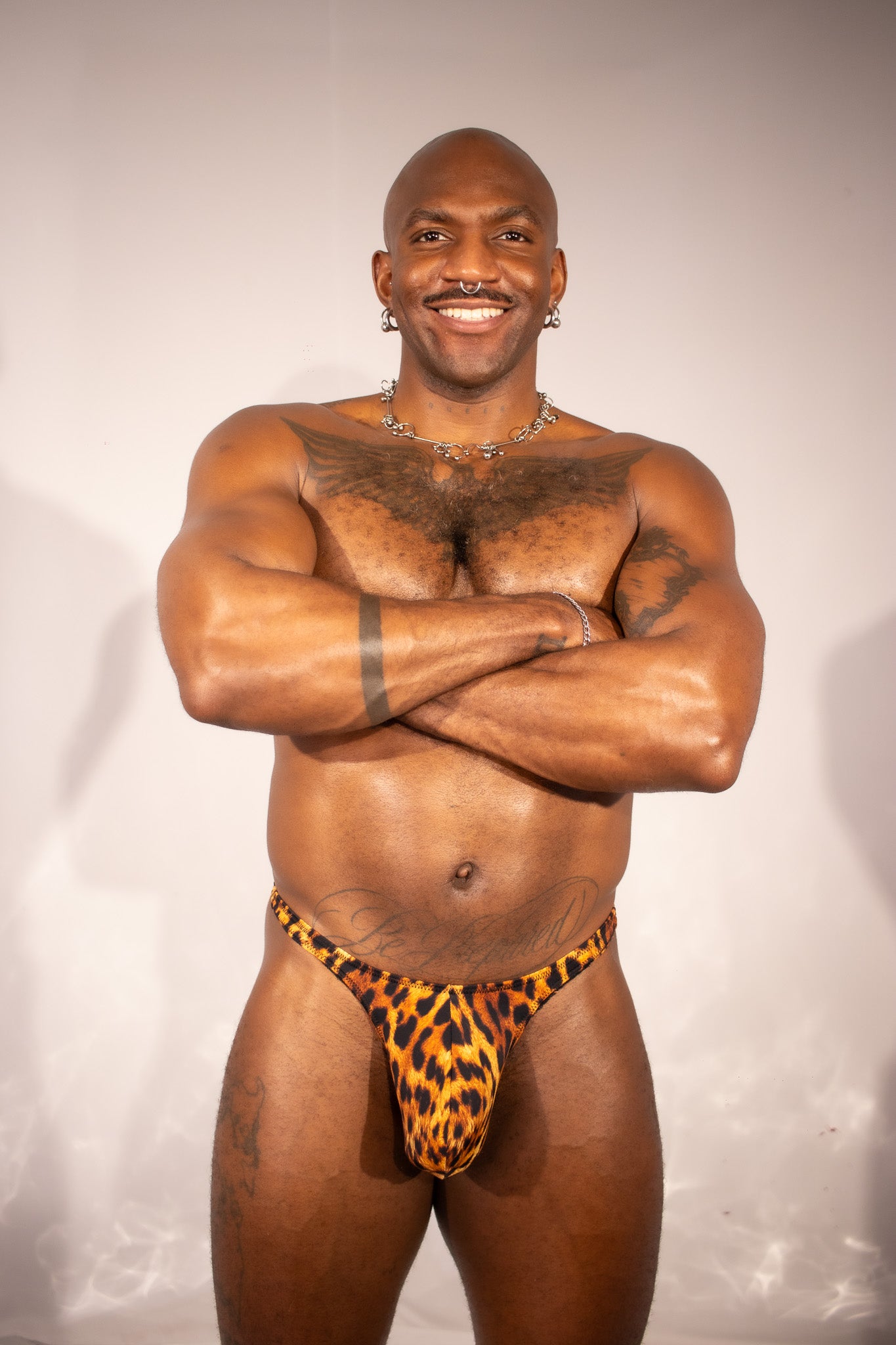Man wearing a leopard print thong against a plain background