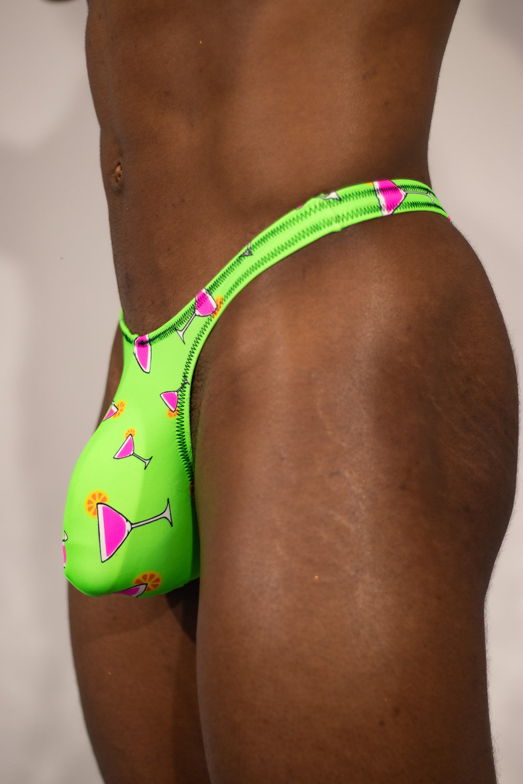 Green thong with pink accents on a plain background