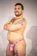 Man wearing pink thong with a white background